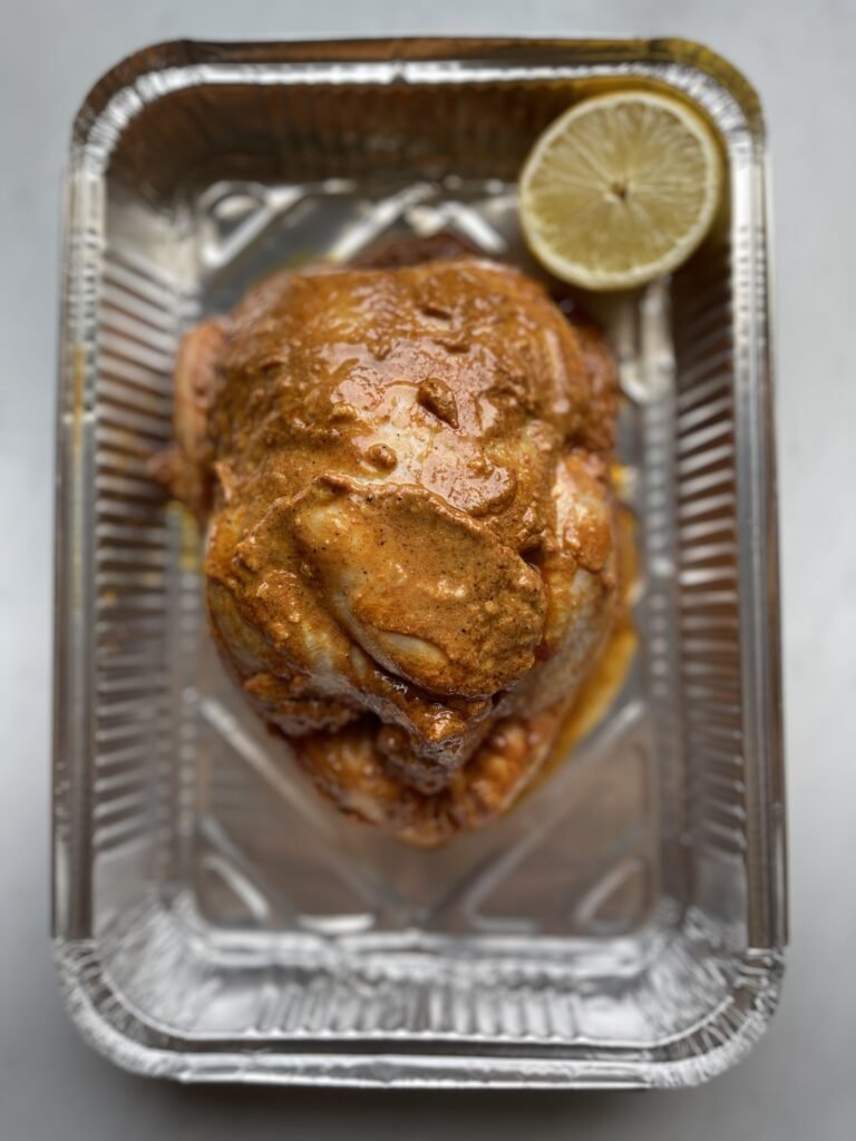marinated middle eastern whole chicken in aluminum tray