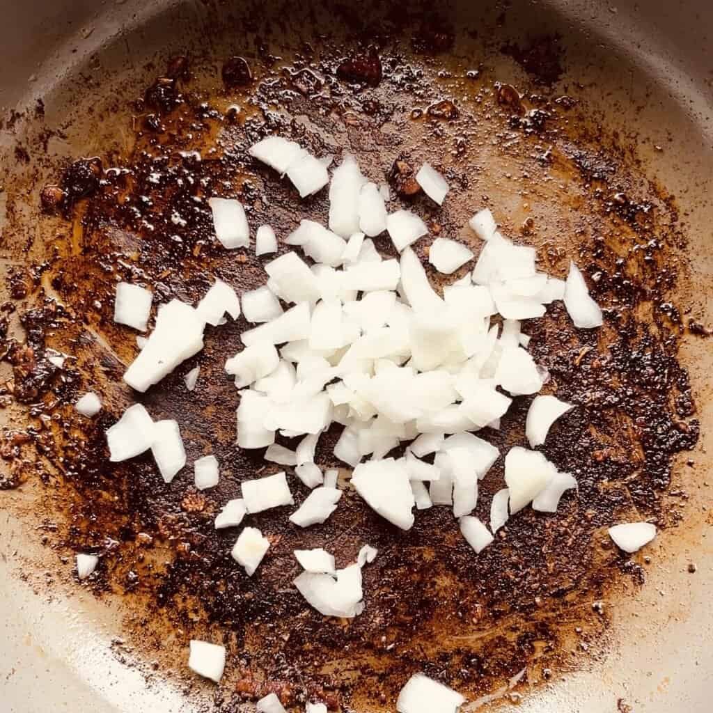 Sautéed onions and spices in a skillet for creamy Italian chicken pasta recipe.