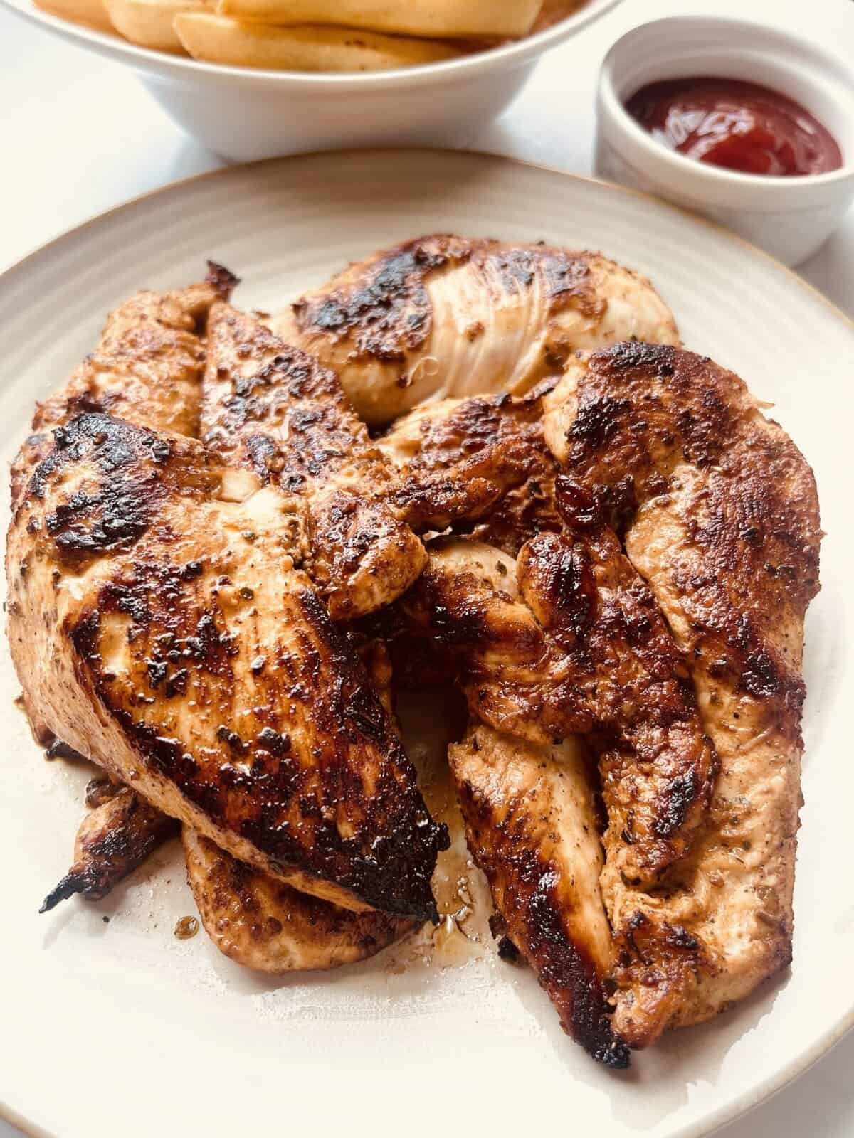 Juicy lemon garlic chicken thighs with crispy, flavorful skin on a white plate.