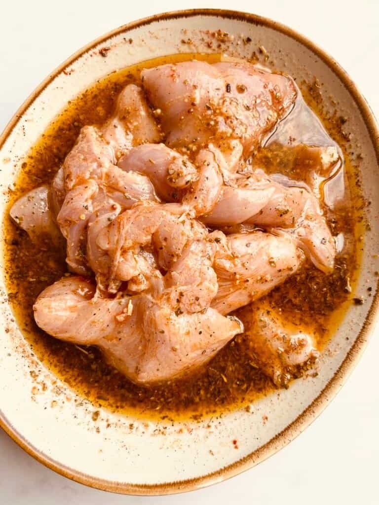 Juicy lemon garlic chicken pieces in flavorful marinade for a delicious recipe.