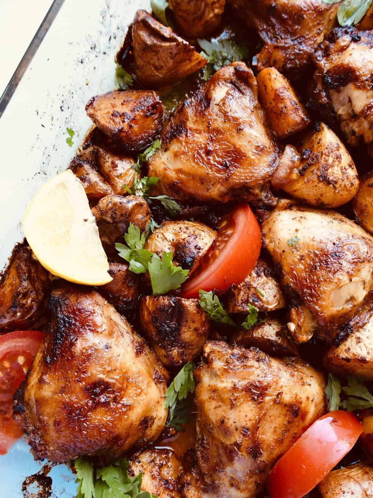 Juicy paprika chicken and roasted potatoes with fresh herbs and lemon wedge.