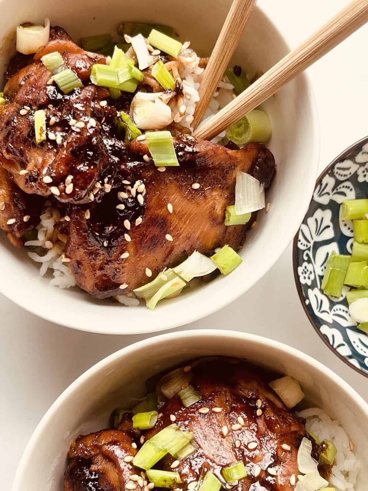 soy garlic chicken served over rice with chopped green onions and sesame seeds.