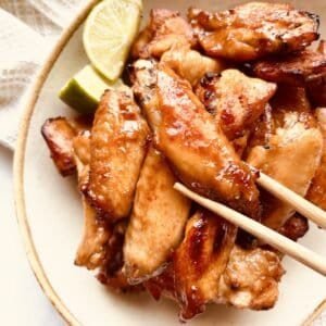 Sticky Gochujang Chicken Wings with Lime Wedges, perfect for Asian-inspired appetizers.