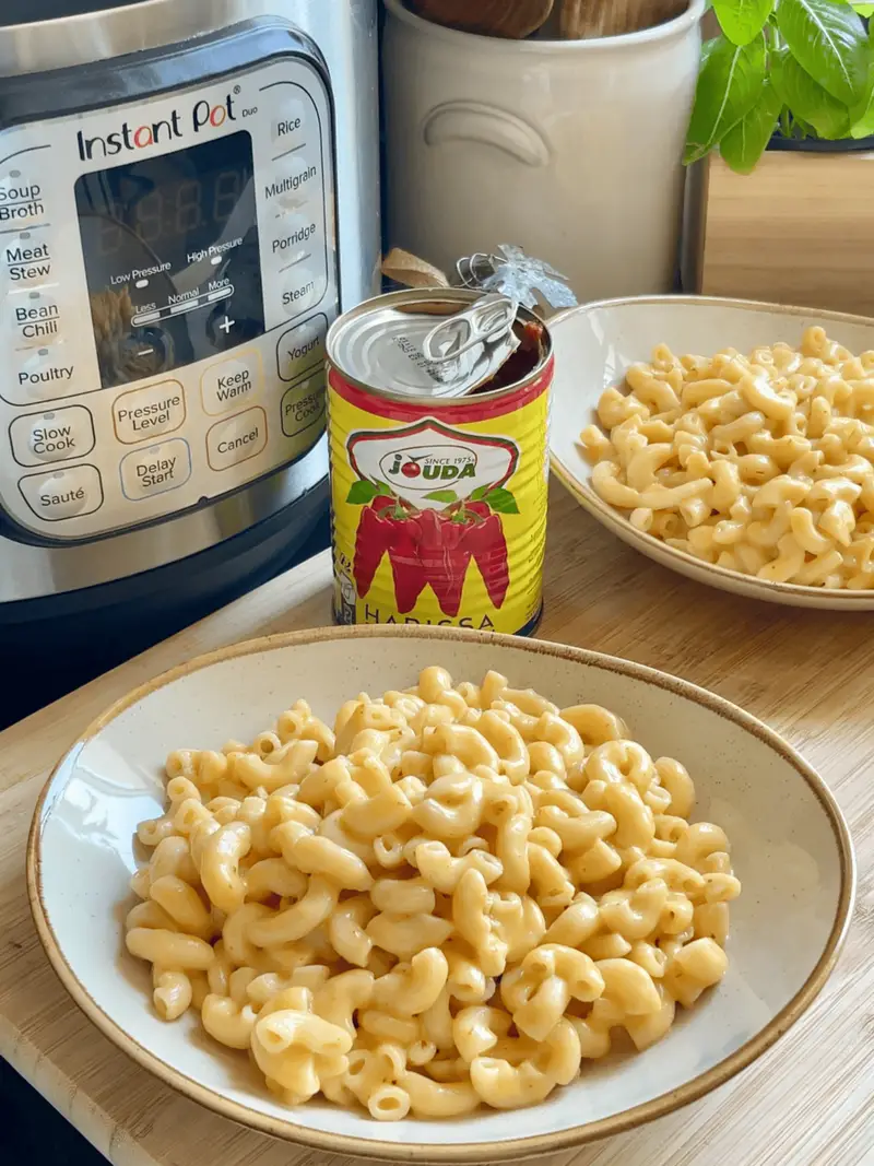 Creamy mac and cheese with harissa in an Instant Pot, served in white bowls for a quick and flavorful meal.