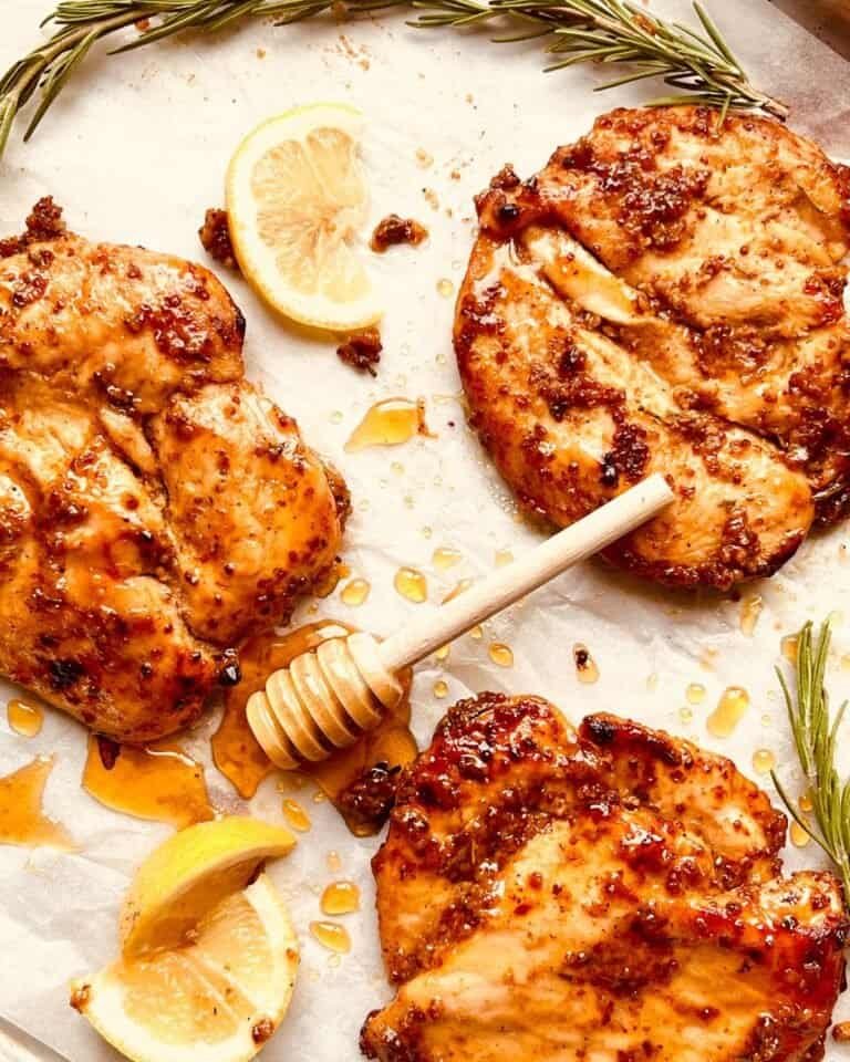 Grilled chicken thighs with honey and lemon, garnished with rosemary and drizzled with honey. Perfec.