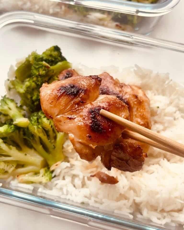 Grilled chicken skewer with rice and broccoli in a glass meal prep container.