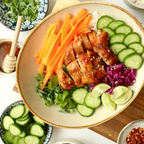 Grilled honey chicken with fresh cucumber, carrots, and rice bowl for healthy eating.