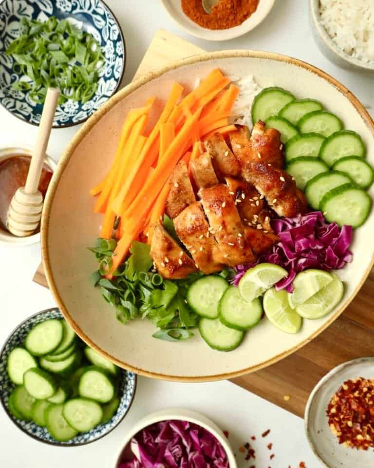 Grilled honey chicken with fresh cucumber, carrots, and rice bowl for healthy eating.