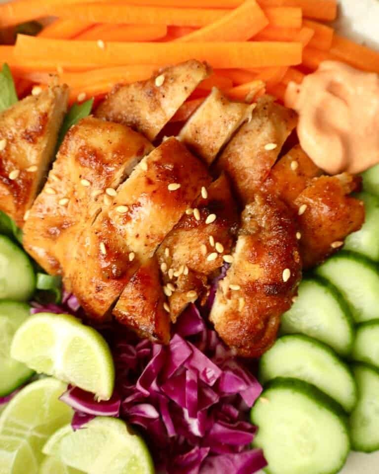 Grilled chili honey chicken with fresh cucumber, cabbage, and lime slices for a flavorful meal.