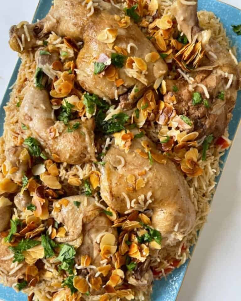 Golden roasted chicken thighs topped with toasted almonds and fresh herbs, served over rice.