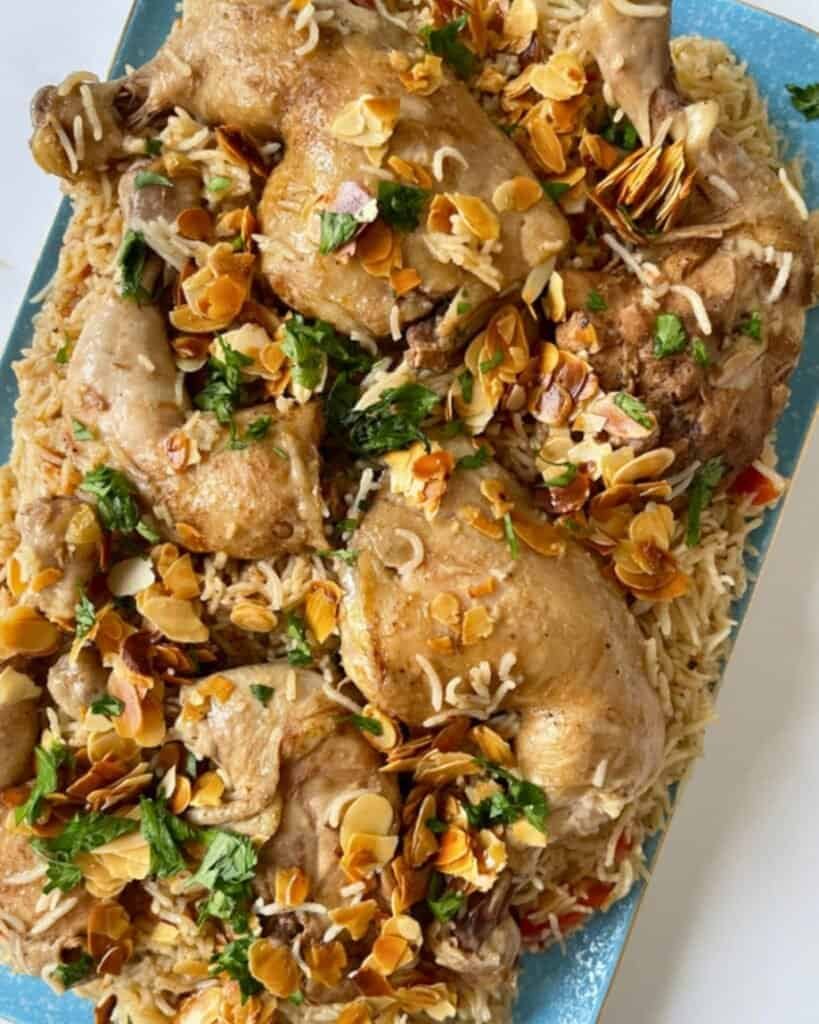 Golden roasted chicken thighs topped with toasted almonds and fresh herbs, served over rice.