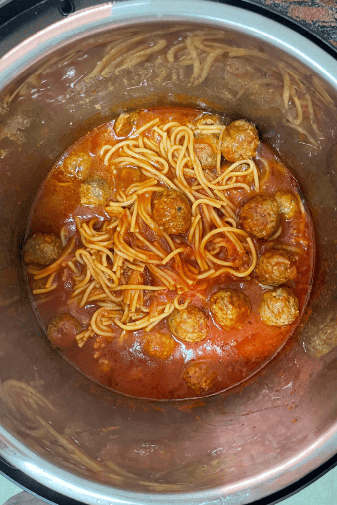 Spaghetti and meatballs in tomato sauce in a pot, ready to serve.
