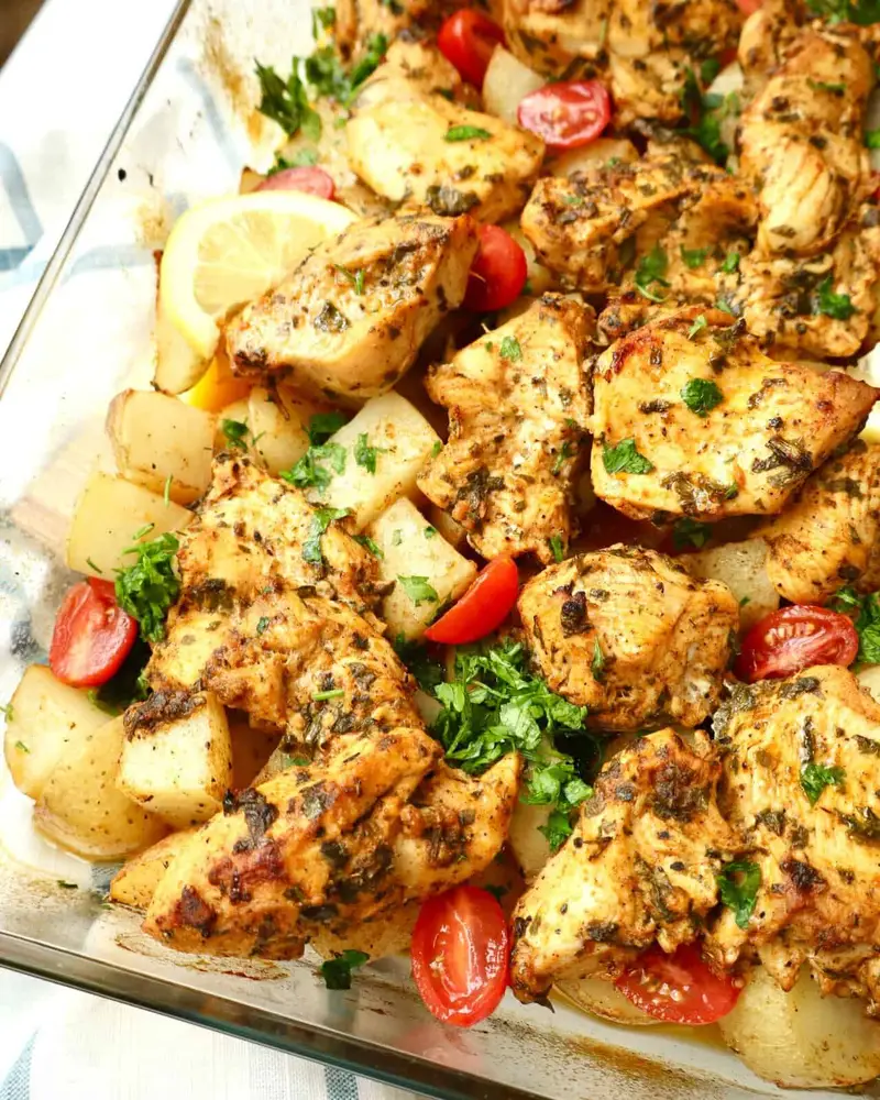 Oven baked chicken and potatoes with crispy edges, juicy chicken, and herb-loaded goodness.