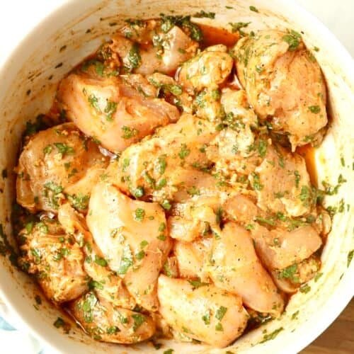 Mediterranean Herb Chicken Marinade in a white glass bowl with fresh herbs