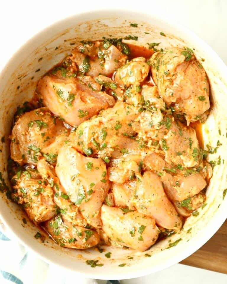 Mediterranean Herb Chicken Marinade in a white glass bowl with fresh herbs
