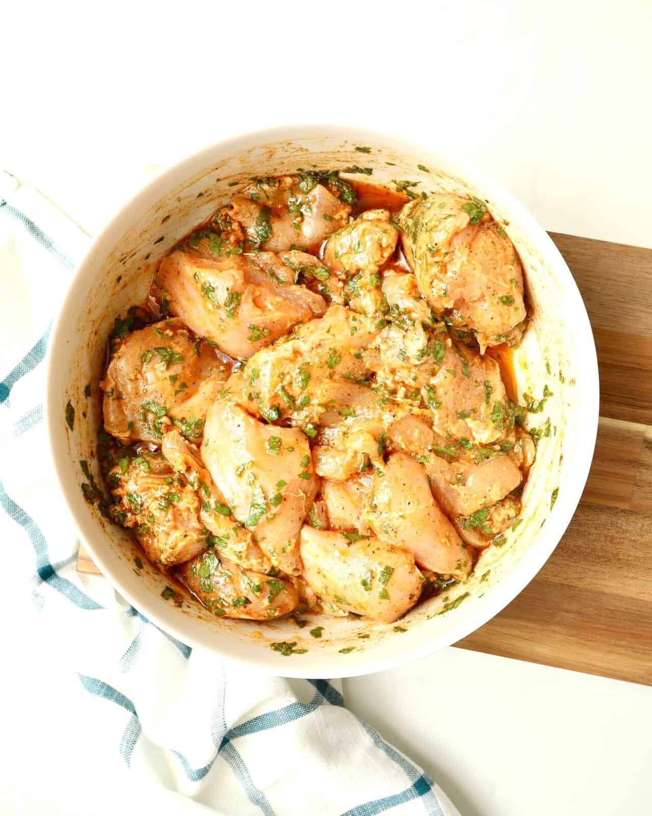Mediterranean Herb Chicken Marinade with olive oil and herbs in glass bowl
