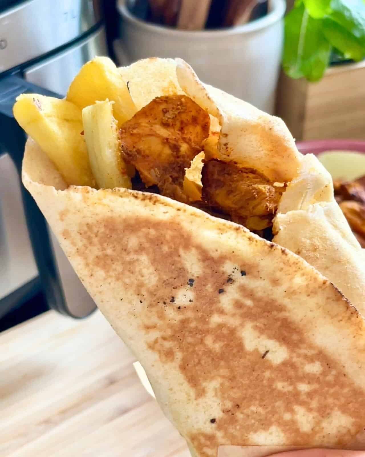 Air fryer chicken shawarma wrap with fries and fresh vegetables.