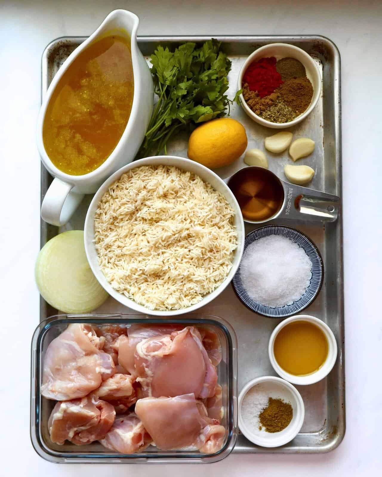 Juicy chicken thighs with rice, herbs, and spices for Mediterranean Chicken and Rice Bake.