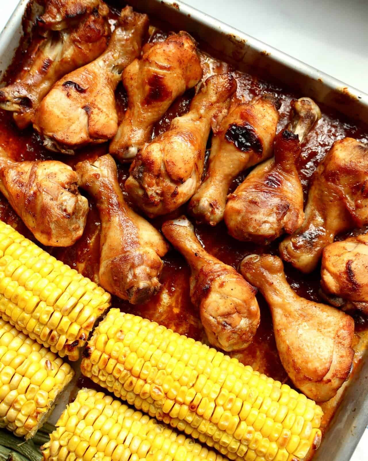Juicy BBQ chicken drumsticks glazed in sticky smoky sauce, roasted with sweet corn on the cob and green beans on one sheet pan—easy, family-friendly weeknight dinner with bold caramelized flavor.