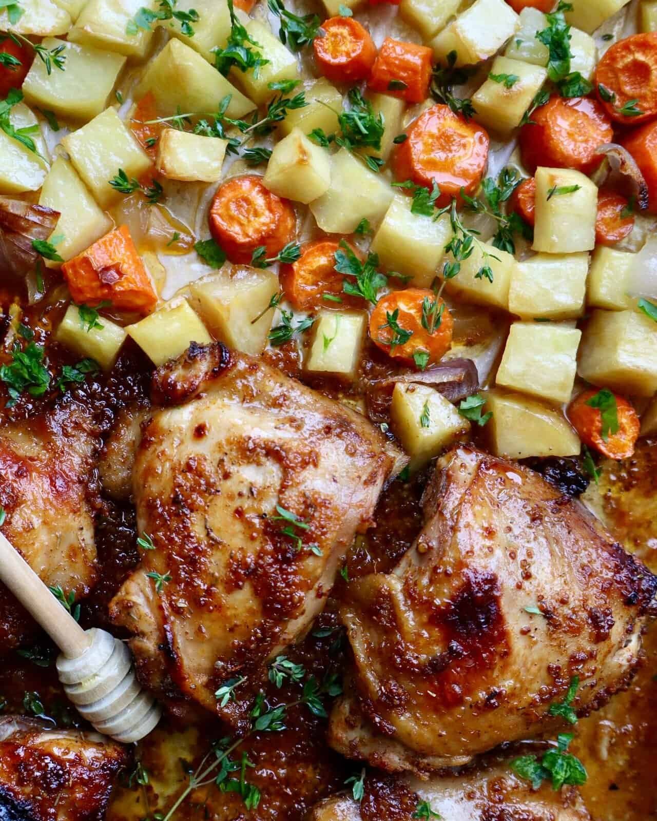 Juicy honey Dijon chicken thighs with roasted vegetables on a sheet pan. Perfect easy dinner recipe.