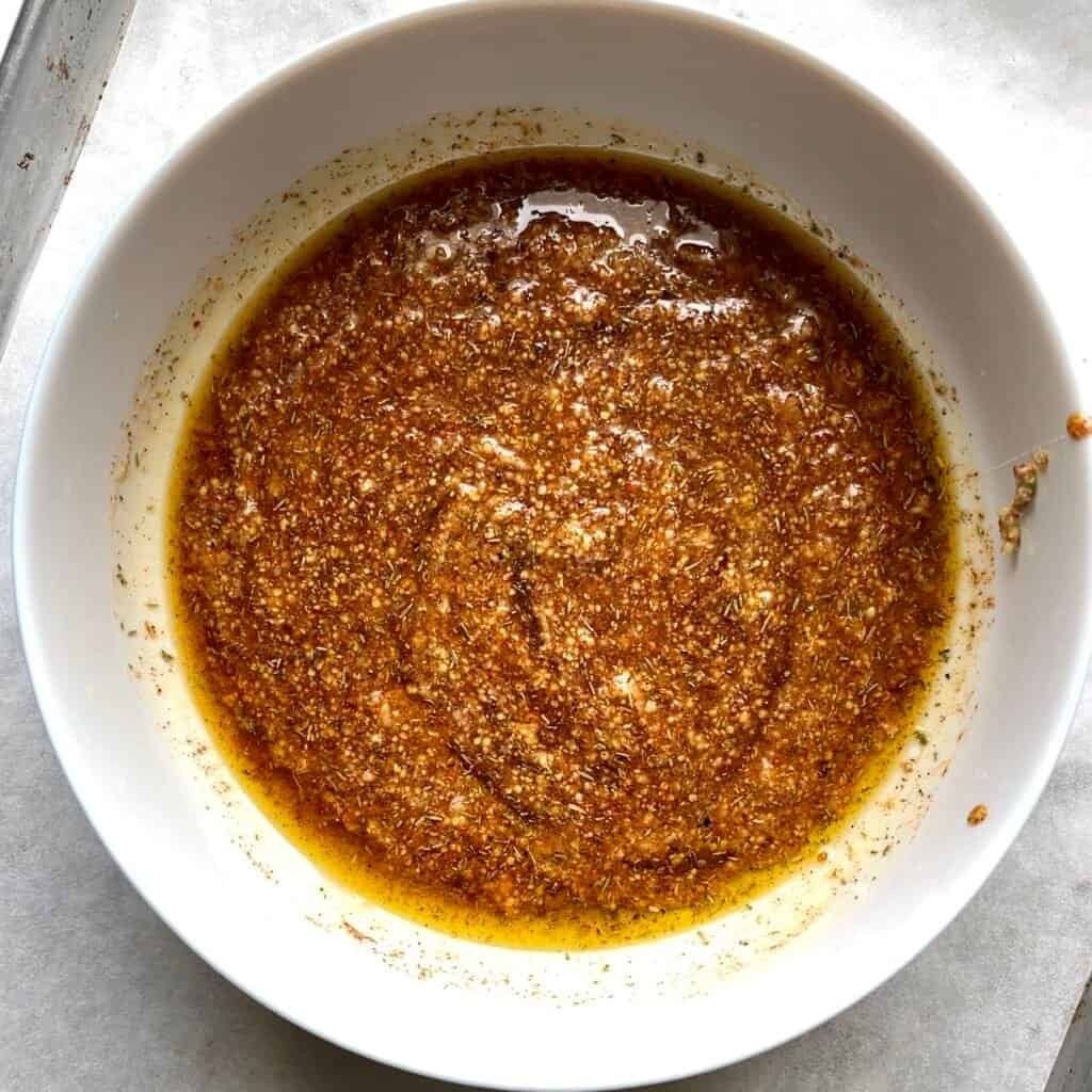 Honey Dijon sauce mixture in a white bowl, ready for sheet pan chicken and vegetables.