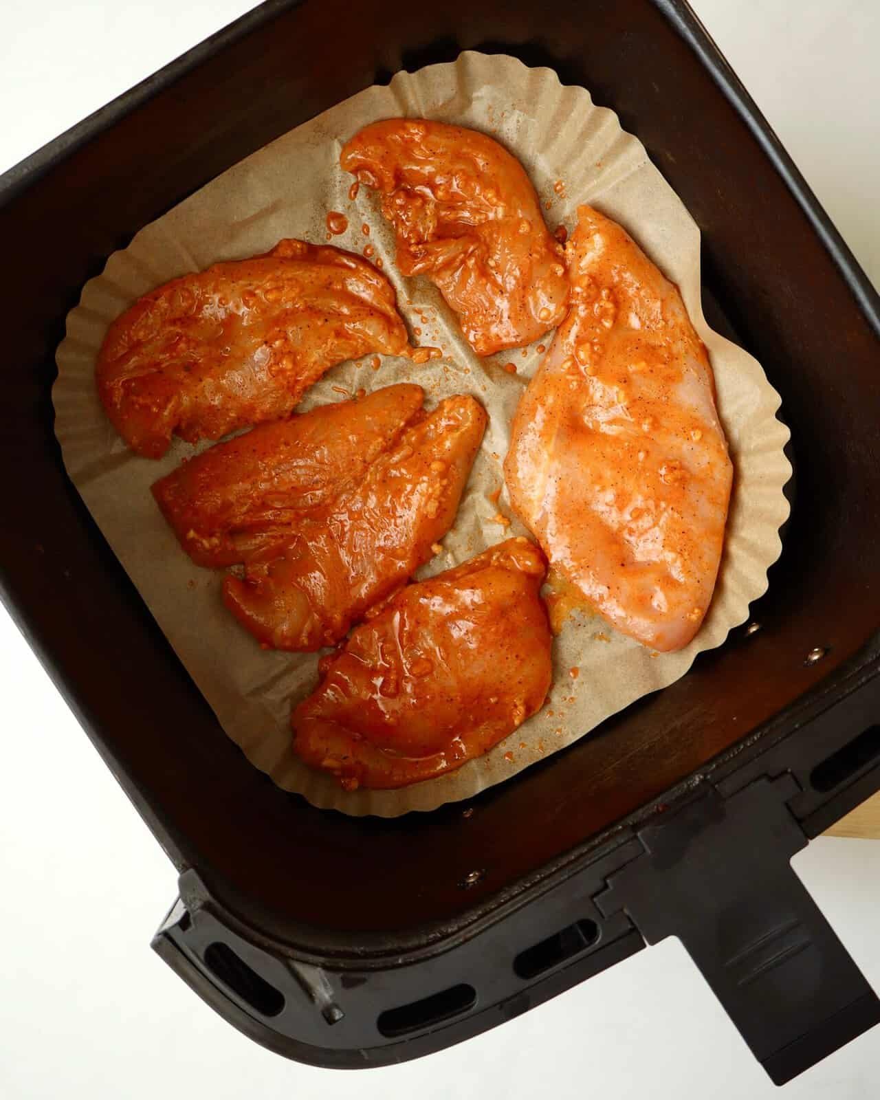 Air fryer chicken pieces marinated and arranged in a single layer for even cooking