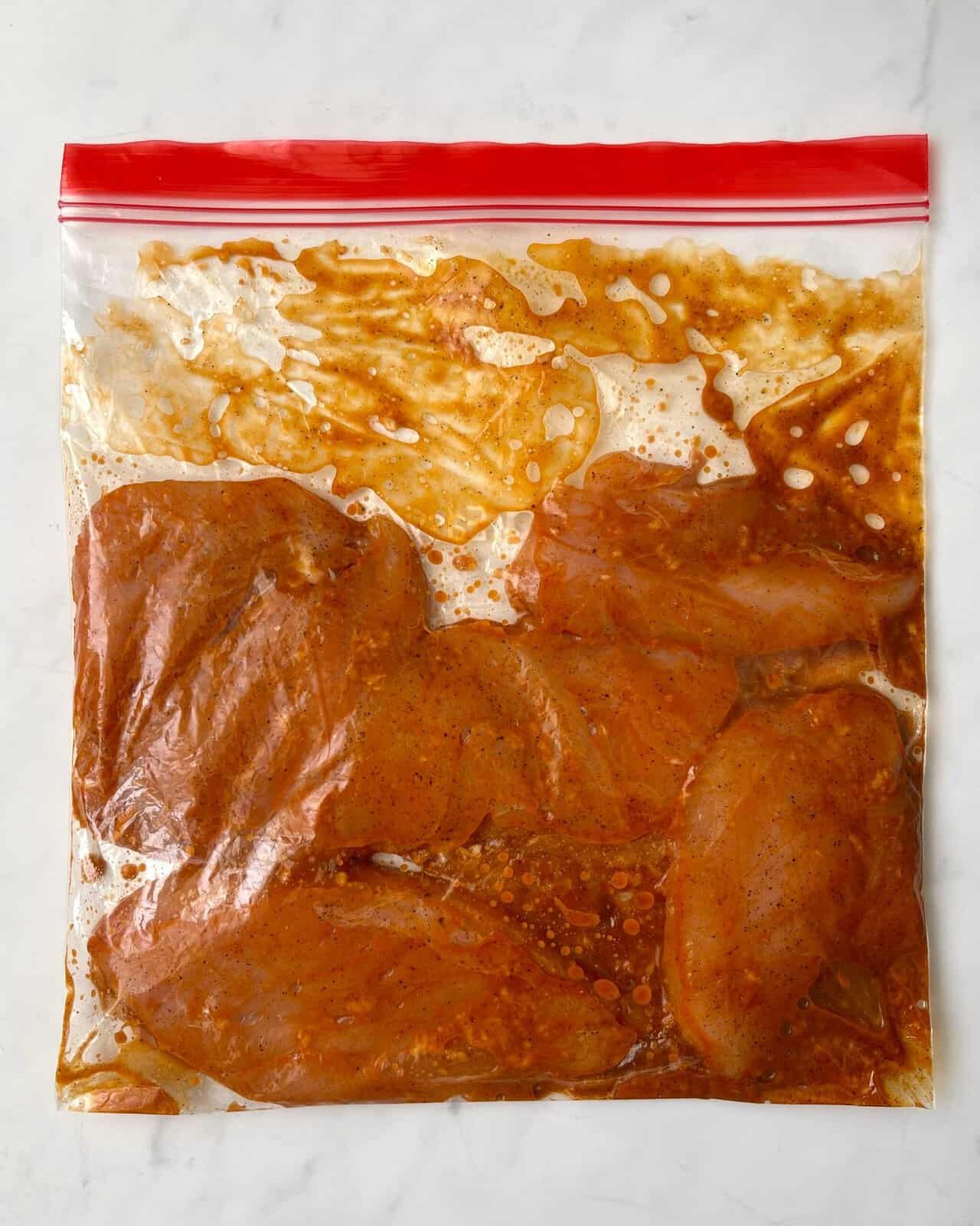 Chicken marinating in a sealed zip-top bag for easy air fryer preparation