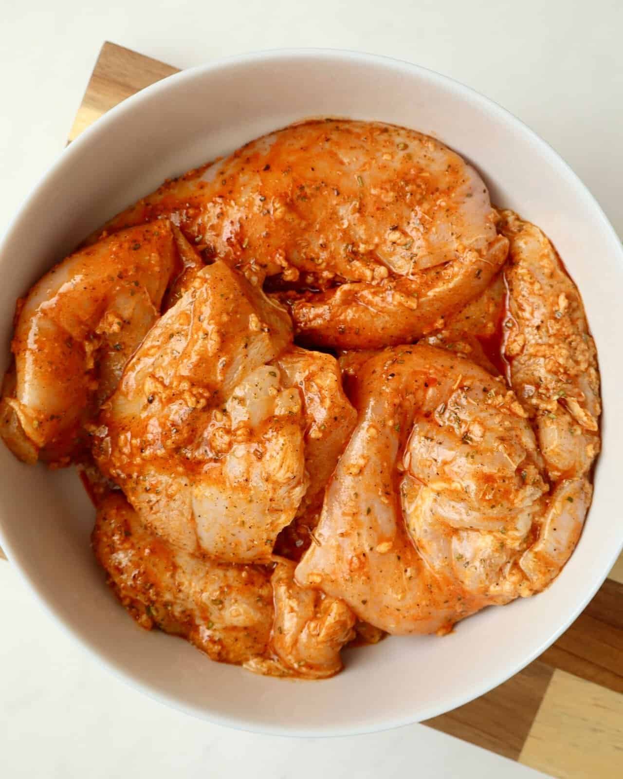 seasoned Chicken breasts in a white bowl