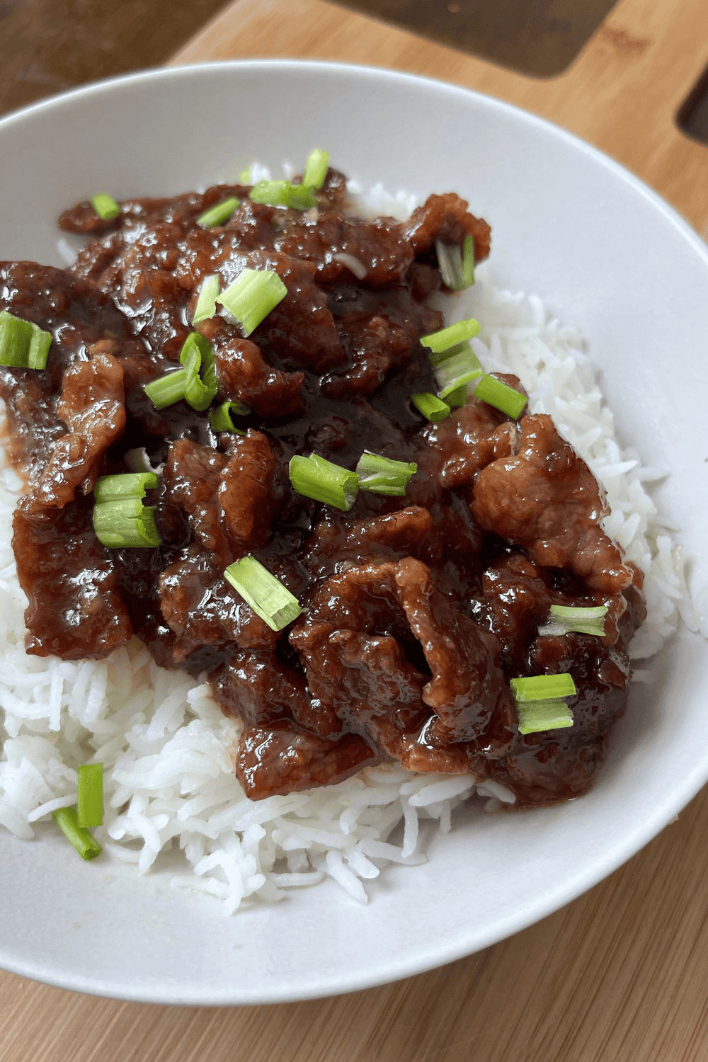 Close up of tender Mongolian beef coated in rich garlic ginger sauce served in a bowl