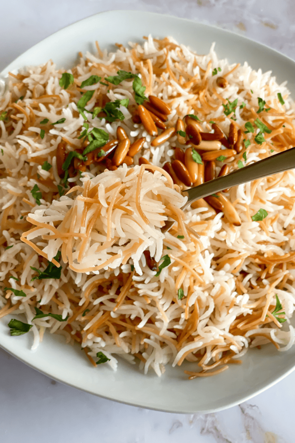Lebanese rice with vermicelli garnished with toasted pine nuts and parsley, a traditional and flavorful rice side dish