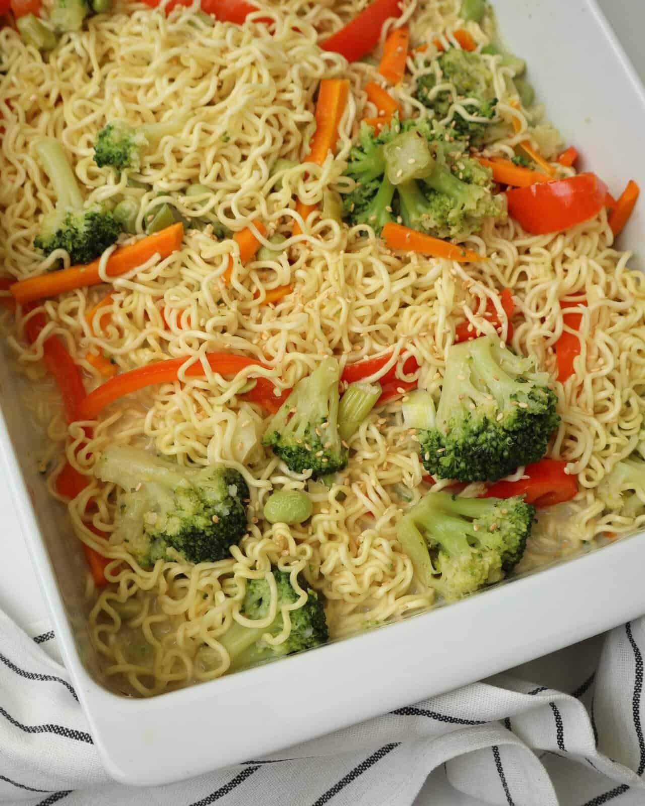 Close up of creamy baked ramen noodles with broccoli, carrots, and edamame