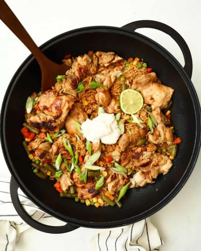Grilled chicken stir-fry with vegetables, lime, and sour cream in a black skillet. Perfect for a qui.
