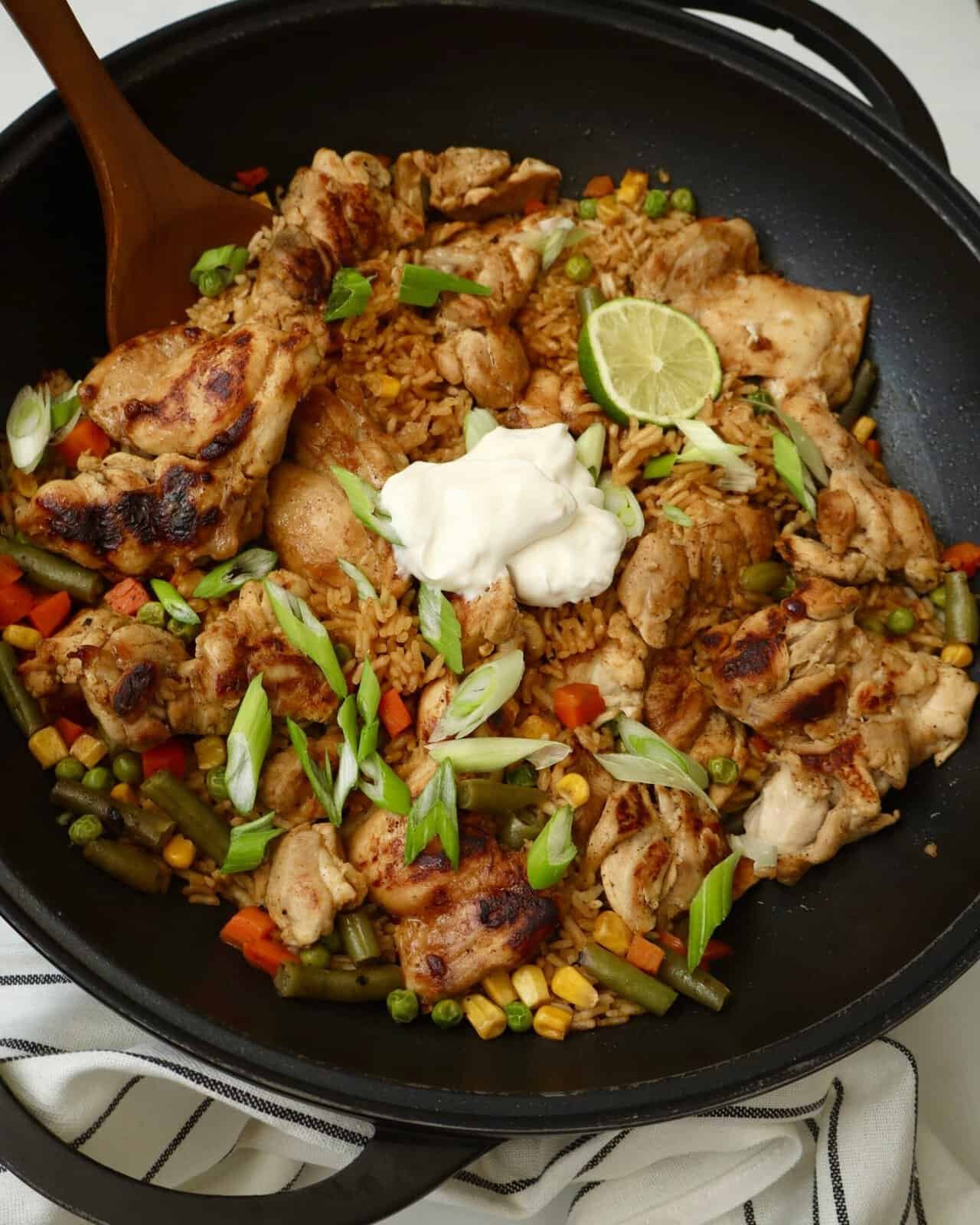 One pan sticky garlic lime chicken and corn rice topped with creamy lime drizzle for an easy family dinner